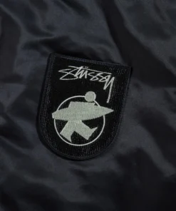 stussy surfman stadium jacket black nylon varsity bomber close up patch